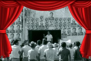 Fotografia em preto e branco de uma espécie de comício. Ao centro e ao fundo, em pé, fotos de Fernando Henrique Cardoso. FHC está em pé, também ao fundo. Em primeiro plano, de costas, pessoas observam o evento.