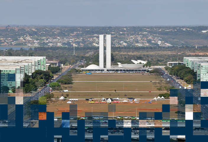 Fotografia colorida que mostra a Esplanada dos Ministérios, em Brasília. À esquerda e à direita, os prédios dos ministérios. Ao centro e ao fundo, o prédio do Congresso Nacional.